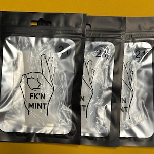 May include: Three black plastic pouches with a clear window, each containing a product. The pouches have a graphic of a hand gesture and the text "F*K'N MINT". Each pouch has a circular sticker with the number "21".