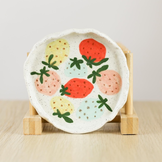 Hand-thrown ceramic strawberry dish with real charm — the kind of tiny handmade piece that makes a vanity or desk feel curated.
