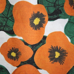 Close up napkin with large wonky nasturtium design print on off white base colour, 94%cotton/6% linen textured fabric.