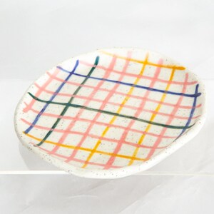 13.5cm ceramic mini plate with check design. Colours are yellow, pink,blue and green on white speckled clay.