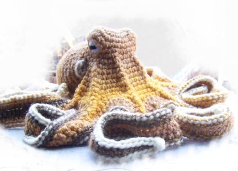 May include: A crocheted octopus plush toy with brown, yellow, and white yarn. The octopus has eight tentacles and a round head with two eyes.