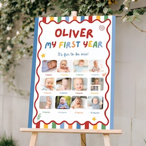 Può includere: Un cartello colorato su un cavalletto di legno, con il testo "OLIVER MY FIRST YEAR" in rosso e blu. Il cartello include una serie di foto del bambino, una per ogni mese del primo anno del bambino. È inclusa anche la frase "It's fun to be one!".