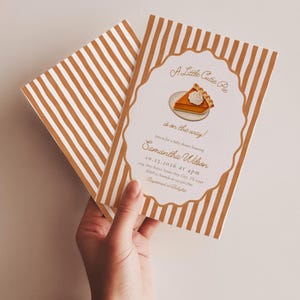 Puede incluir: Una tarjeta de invitación rectangular para baby shower con fondo blanco y rayas verticales de color naranja quemado. El centro tiene un marco festoneado con un gráfico de una porción de tarta y el texto A Little Cutie Pie is on the way.