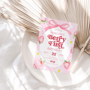 Puede incluir: Invitaci&oacute;n de cumplea&ntilde;os rosa con un dise&ntilde;o de fresa acuarela. La invitaci&oacute;n dice "Join us for Penelope's Berry First Birthday, Sept 22, 3PM".