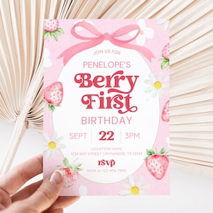 Berry First Birthday invitation featuring a sweet strawberry theme with a soft pink background, playful retro-style red lettering, and daisy accents. The design includes a pink bow at the top, fresh strawberries around the edges, and white floral details for a cheerful boho vibe. Perfect for celebrating a little girl’s first birthday with a fun and trendy berry-inspired party theme.