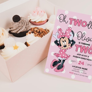 May include: A pink polka-dotted invitation with Minnie Mouse graphics and the text "Oh TWOdles Olivia is turning TWO." A box of cupcakes with various toppings sits to the left.