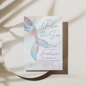 May include: An invitation to an "Under the Sea" themed party for a little mermaid named Madison turning 3. The invitation features a colorful mermaid tail with gold glitter and a blue and white background with bubbles.