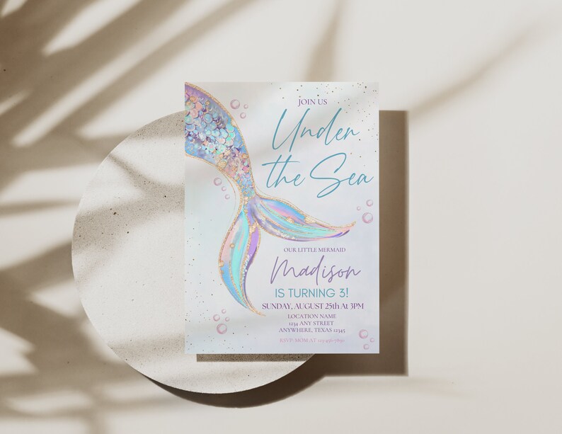 May include: An invitation to an "Under the Sea" themed party for a little mermaid named Madison turning 3. The invitation features a colorful mermaid tail with gold glitter and a blue and white background with bubbles.