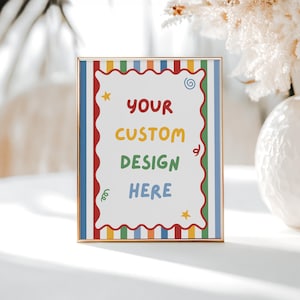 May include: A rectangular gold-toned frame containing a white sign with a scalloped red border. The sign features vertical stripes in red, blue, green, and yellow, with the text "YOUR CUSTOM DESIGN HERE" in colorful letters and small star and swirl icons.