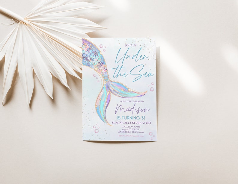May include: A light blue and purple mermaid tail with gold glitter accents on a white background. The text "Join Us Under the Sea" is written in blue script. The text "Our Little Mermaid Madison is Turning 3!" is written in black. The text "Sunday, August 25th at 3PM" is written in black. The text "Location Name Any Street Anywhere, Texas" is written in black.
