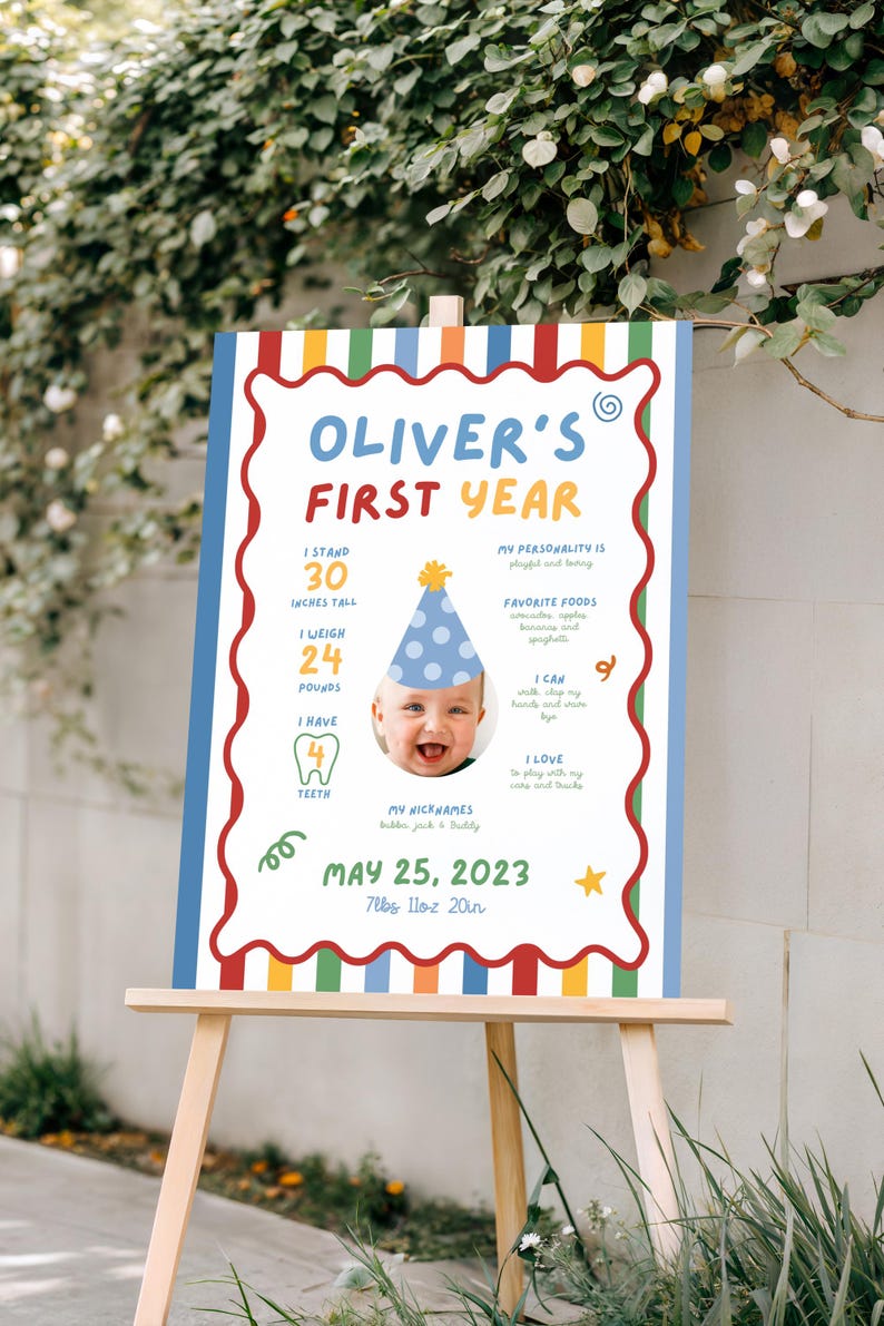 K&ouml;nnte beinhalten: Ein farbenfrohes Schild auf einer Staffelei, das das erste Jahr eines Babys feiert. Das Schild enth&auml;lt den Text "Oliver's First Year", ein Babyfoto und Details: 76 cm gro&szlig;, 10,9 kg, 4 Z&auml;hne und das Datum 25. Mai 2023.