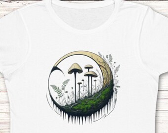 Puede incluir: Camiseta blanca con un gráfico de setas que crecen en forma de media luna con musgo verde y follaje.