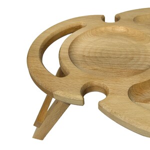 May include: A wooden picnic serving tray with a built-in bottle holder and four separate serving bowls. The tray has a natural wood finish and folds into a compact size for easy storage.