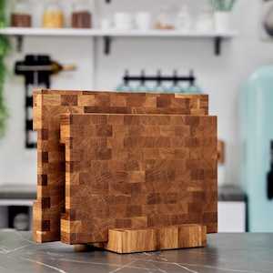 Könnte beinhalten: Drei Schneidebretter aus Holz mit einem Blockständer. Die Bretter sind aus hellbraunem Holz mit einem Schachbrettmuster. Der Ständer ist aus dem gleichen Holz.