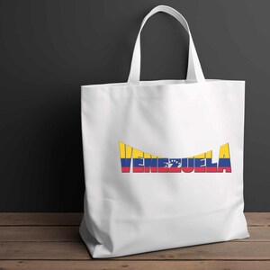 May include: White tote bag with a yellow, blue, and red graphic of the word "Venezuela" with the colors of the Venezuelan flag.