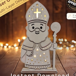Op de afbeelding: Een lichtgekleurde, lasergesneden houten figuur van Sinterklaas die een mijter met een kruisvormige uitsparing draagt en een staf vasthoudt. Het ontwerp heeft stervormige uitsparingen waardoor licht schijnt voor een gloeiend effect.