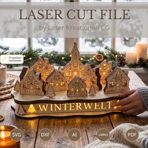 May include: A laser-cut wooden village display featuring multiple small houses and a central church structure. The base is illuminated from within and displays the text WINTERWELT. The design includes intricate cutouts and small evergreen trees.