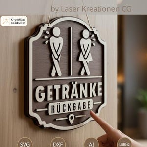 May include: A dark brown and white wooden wall sign featuring the text GETRÄNKE RÜCKGABE and two stylized figures with crossed legs. The sign is suspended by a string and includes a location pin icon at the bottom, designed as a laser cut file.