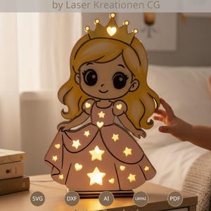 Può includere: Lampada in legno a forma di principessa con corona e ritagli a forma di stella. La lampada è dipinta di rosa e giallo, con il testo "LASER CUT FILE" e "by Laser Kreationen CG". La lampada è illuminata.