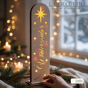 May include: A tall, arched wooden light display featuring a laser-cut star at the top and the German word Winterzauber in cursive script. The design includes small star cutouts and emits a warm glow from within the light-colored wood structure.