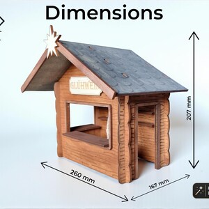 May include: A wooden model of a market stall with a dark gray roof, a star ornament at the peak, and a sign reading GL&Uuml;HWEIN. The structure features a service counter and an open doorway. Dimensions are 260 mm wide, 167 mm deep, and 207 mm high.