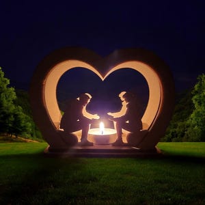 May include: A wooden heart-shaped candle holder with two silhouettes of people holding hands inside. The candle holder is lit with a warm glow, creating a romantic ambiance.
