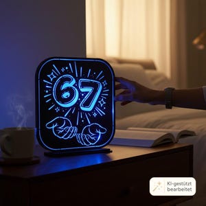 May include: A square-shaped LED light display featuring the number 67 in a bold, outlined font, surrounded by radiating starburst accents and two open hands at the bottom. The design glows with a vibrant blue light against a dark background.