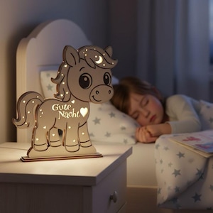 K&ouml;nnte beinhalten: Ein h&ouml;lzernes Nachtlicht in Pferdeform mit den Worten "Gute Nacht" und einem Herz-Ausschnitt. Das Licht steht auf einem Nachttisch. Das Pferd hat Mond- und Stern-Ausschnitte.