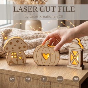 Puede incluir: Tres decoraciones de madera clara cortadas con láser que representan una casa seta, una calabaza con un corazón recortado y un farol. Cada pieza tiene iluminación interior cálida. El texto LASER CUT FILE by Laser Kreationen CG es visible.
