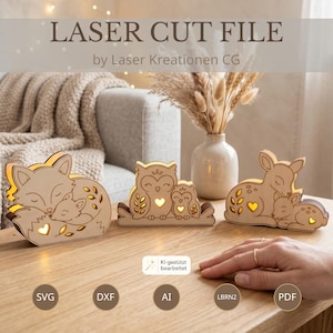 May include: Three laser-cut wooden light boxes featuring animal pairs: a fox, an owl, and a deer, each with a glowing heart cutout. The text reads LASER CUT FILE by Laser Kreationen CG, with file formats SVG, DXF, AI, LBRN2, and PDF listed below.