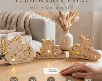May include: Three laser-cut wooden light boxes featuring animal pairs: a fox, an owl, and a deer, each with a glowing heart cutout. The text reads LASER CUT FILE by Laser Kreationen CG, with file formats SVG, DXF, AI, LBRN2, and PDF listed below.