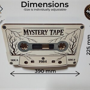 May include: A wooden cassette tape design with the text "MYSTERY TAPE" and "1984". The dimensions are approximately 15.35 inches wide and 8.86 inches high. The design includes tree branch details and is labeled "SIDE A" and "SIDE B".