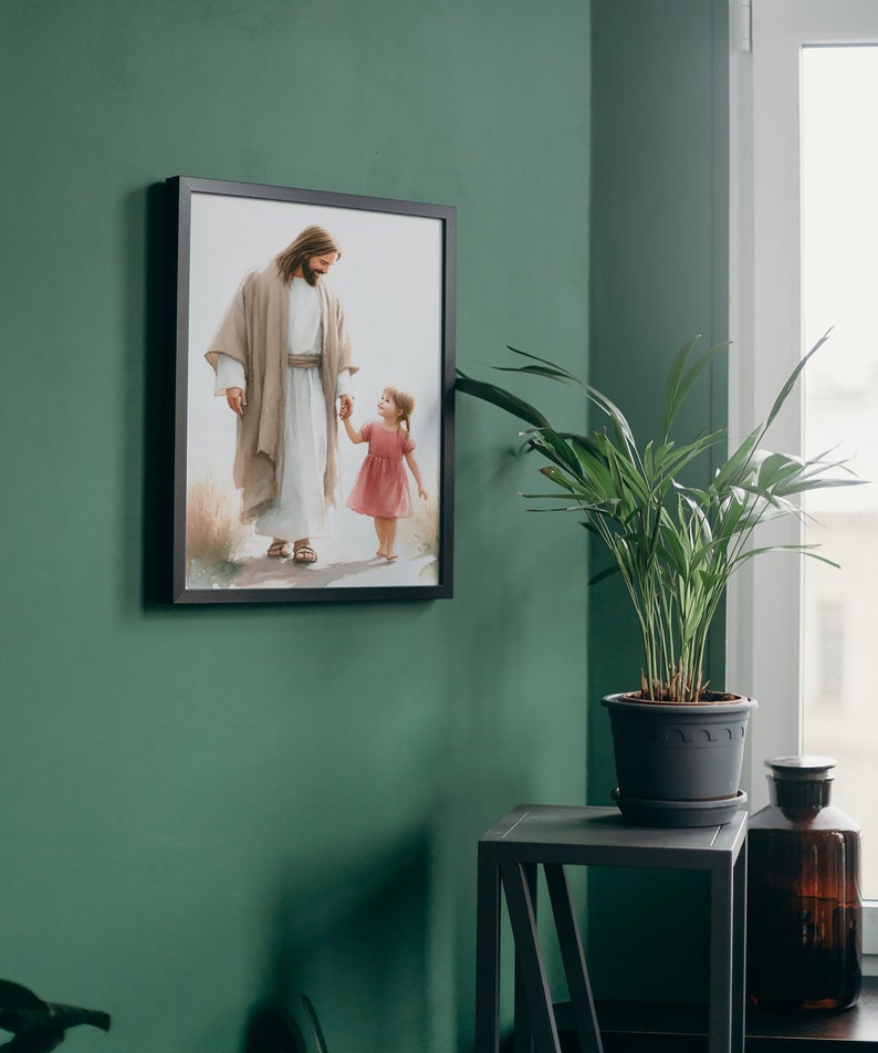 May include: A framed painting of Jesus walking with a young girl, both holding hands. The painting is on a green wall with a potted plant and a small table in the corner.