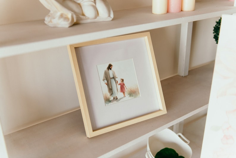 May include: A framed picture of a man in a white robe holding a young girl's hand. The picture is on a white shelf with other decorative items.