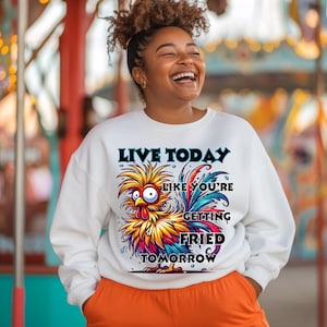 May include: White sweatshirt with a colorful cartoon rooster and the text "Live Today Like You're Getting Fried Tomorrow".