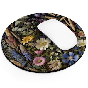May include: A round mouse pad with a floral design. The design features a variety of flowers in shades of yellow, pink, blue, and white on a black background.