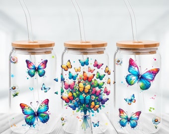 May include: Three glass jars with bamboo lids and clear straws. Each jar features a different butterfly design. One jar has a large butterfly with colourful wings, another has a bouquet of butterflies, and the third has a single butterfly with blue and pink wings.