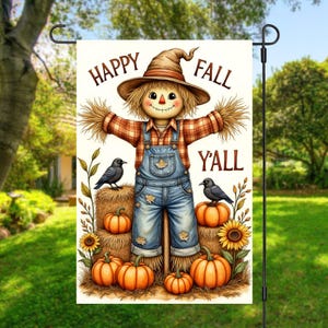 Puede incluir: Una bandera de jardín con un espantapájaros sonriente con un mono, una camisa a cuadros y un sombrero de paja. La bandera dice "Happy Fall Y'all" e incluye calabazas, girasoles y cuervos. La bandera se muestra en un soporte de metal negro.