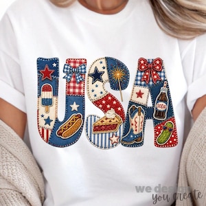 Puede incluir: Una camiseta blanca con un gráfico grande de las letras USA. Las letras están rellenas con un mosaico de patrones rojos, blancos y azules, incluyendo estrellas, rayas, cuadros vichy e ilustraciones de un helado, perrito caliente, tarta, bota y refresco.