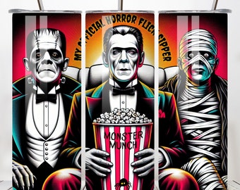 Może przedstawiać: Trzech bohaterów filmów grozy, Frankenstein, Dracula i Mumia, siedzi w kinie z wiaderkiem popcornu, na którym widnieje napis "Monster Munch". Tekst na kubku brzmi "My Official Horror Flick Sipper".