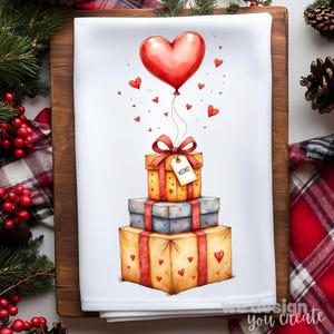Puede incluir: Un paño de cocina blanco con una ilustración de acuarela de tres cajas de regalo apiladas. Un globo rojo en forma de corazón flota encima, conectado por una cuerda a la caja superior. La caja superior tiene una etiqueta que dice "XOXO". Pequeños corazones rojos están dispersos.