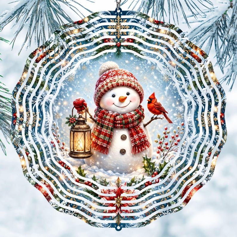 May include: A circular metal wind spinner featuring a festive winter scene with a snowman wearing a red patterned hat and scarf. The snowman holds a glowing lantern, accompanied by a red cardinal bird, holly, and poinsettia accents.