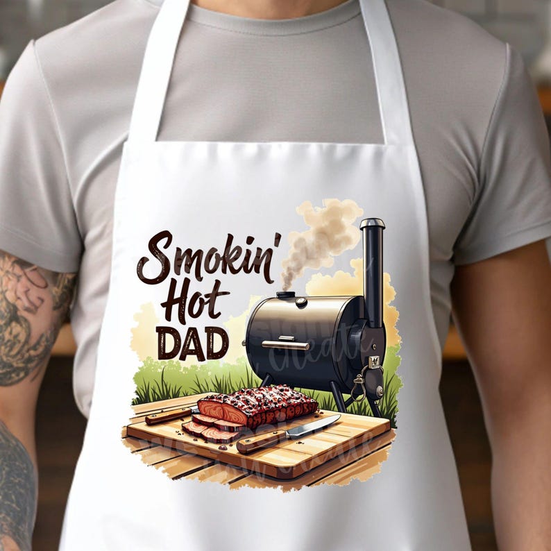 May include: White apron with a black and brown smoker grill, a wooden cutting board with sliced meat, and the text "Smokin' Hot Dad".