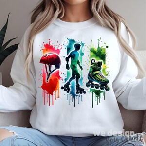Puede incluir: Sudadera blanca con un diseño de acuarela de equipo de patinaje sobre ruedas. El diseño incluye un casco rojo, una silueta de patinador y un patín verde, todos con vibrantes efectos de salpicaduras de pintura.