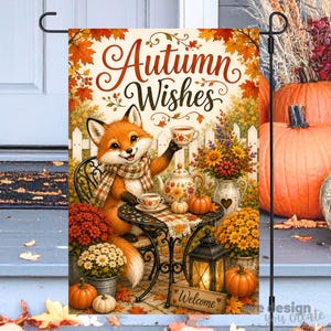 Puede incluir: Una bandera de jardín rectangular que muestra un zorro con una bufanda de cuadros, sentado a una mesa con una tetera y una taza. El texto "Autumn Wishes" aparece arriba. La escena incluye calabazas, flores de otoño y un farol.
