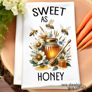 May include: White kitchen towel with a "Sweet as Honey" design. The design features a jar of honey, bees, flowers, and a honeycomb. The words "Sweet as Honey" are printed in black.