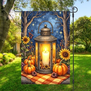 May include: A garden flag featuring a fall scene with a lit lantern, pumpkins, sunflowers, and a starry night sky. The lantern has a lit candle inside. The pumpkins are orange, and the sunflowers are yellow. The background is a dark blue with stars.