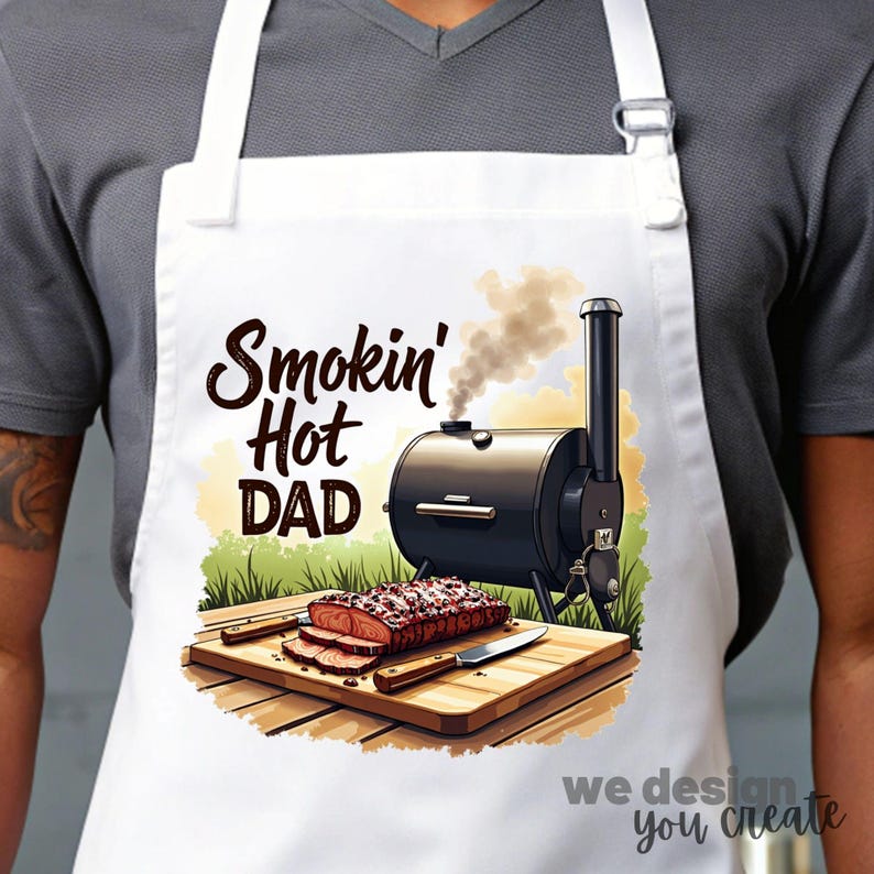 May include: White apron with a black and silver smoker, a wooden cutting board with sliced meat, and the text "Smokin' Hot Dad".