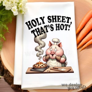 Może przedstawiać: Biały ręcznik kuchenny z kreskówkowym szefem kuchni w postaci świni, w czapce kucharskiej i fartuchu, patrzącym na ciasto. Tekst "HOLY SHEET, THAT'S HOT!" znajduje się nad świnią. Marchewki i kwiaty w tle.