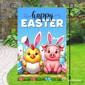 Peut inclure: Un drapeau de jardin Happy Easter avec un fond bleu et une clôture en bois blanc. Un poussin jaune avec des oreilles de lapin et un cochon rose avec des oreilles de lapin sont devant la clôture. Le drapeau porte le texte "Happy Easter" en noir.